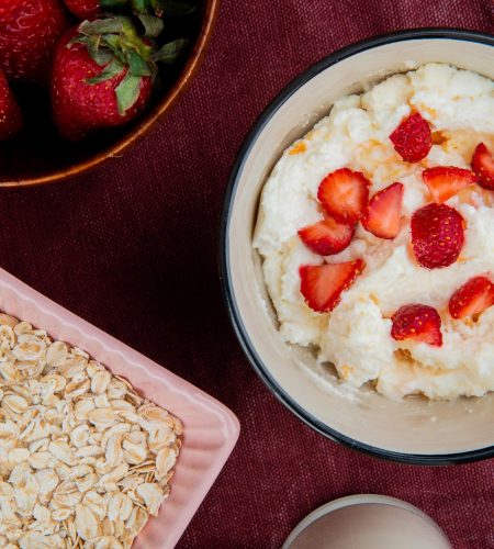 top-view-bowl-cottage-cheese-with-strawberries-bowl-oats-bordo-surface-min